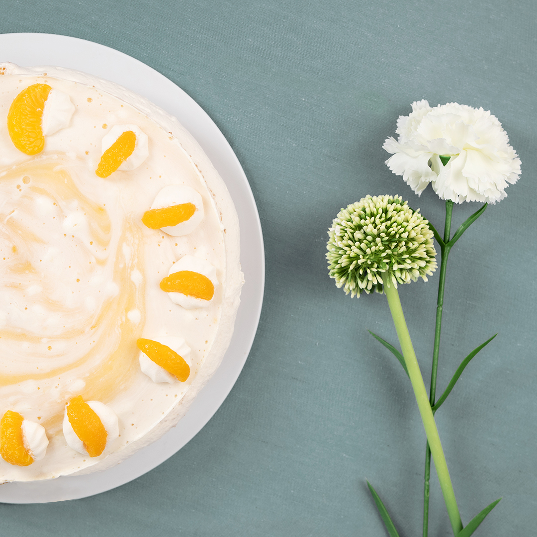 Vegane Mandarine-Sahne Torte  auf weißem Teller von der Seite